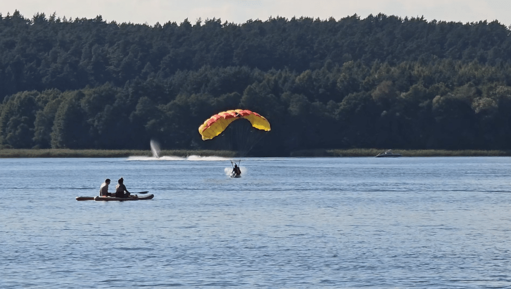 Wszyscy zaskoczeni. Akcja służb ratunkowych na Plaży Miejskiej. - 12 spadochroniarzy wpadło do jeziora Ukiel pełnego turystów. Służby ratunkowe w akcji