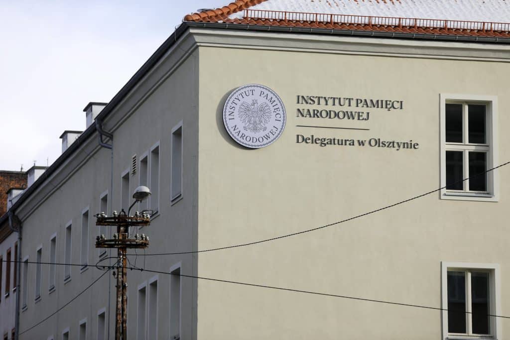Budynek Delegatury IPN w Olsztynie z widocznym logo i nazwą instytucji na ścianie.