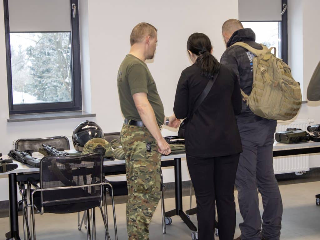 Delegacja ukraińska ogląda wyposażenie i procedury na granicy w pomieszczeniu wewnętrznym.