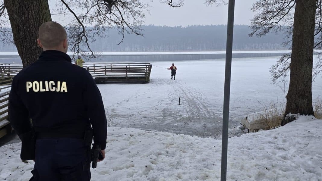 Policjant obserwuje zamarznięte jezioro, na kt&oacute;rym załamał się l&oacute;d, a mężczyzna ratował psa.