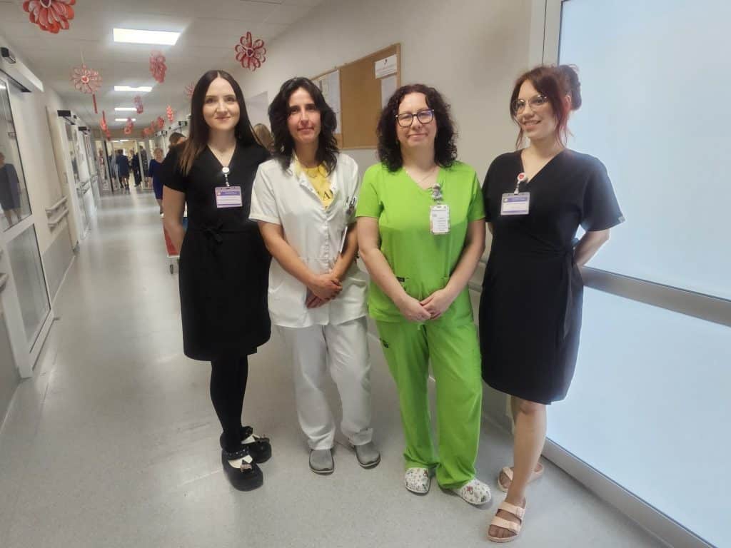 Grupa pielęgniarek i lekarzy na korytarzu szpitala dziecięcego w Olsztynie.