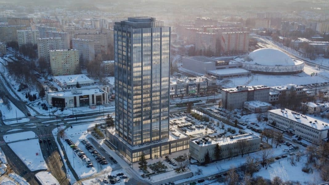Wysoki wieżowiec w Olsztynie na tle miejskiej zabudowy zimą, z planami rozbudowy na 30 pięter.