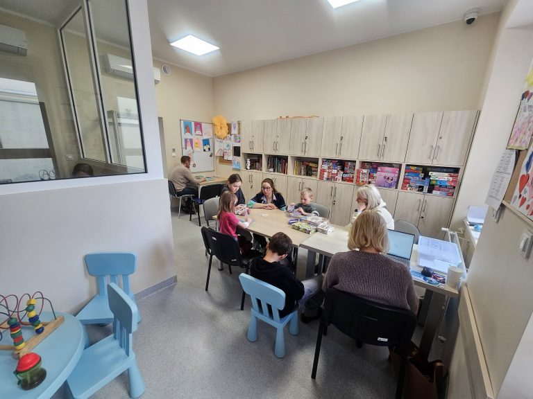 Wewnątrz odnowionego oddziału szpitala dziecięcego w Olsztynie, dzieci i opiekunowie podczas zajęć.