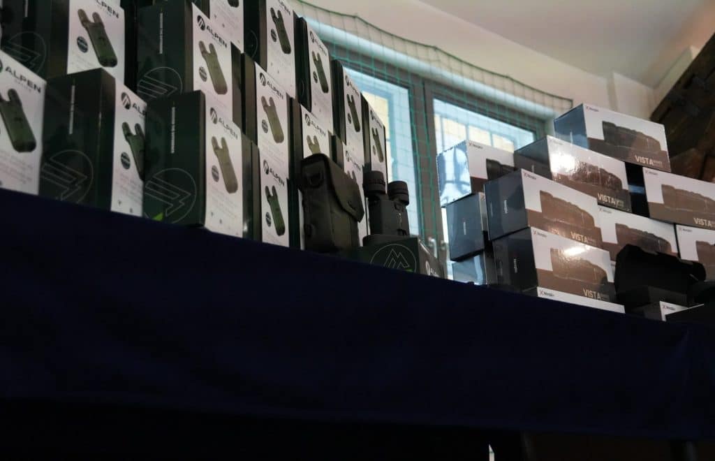 Sprzęt policyjny i akcesoria na stole w pomieszczeniu, w tle okno.