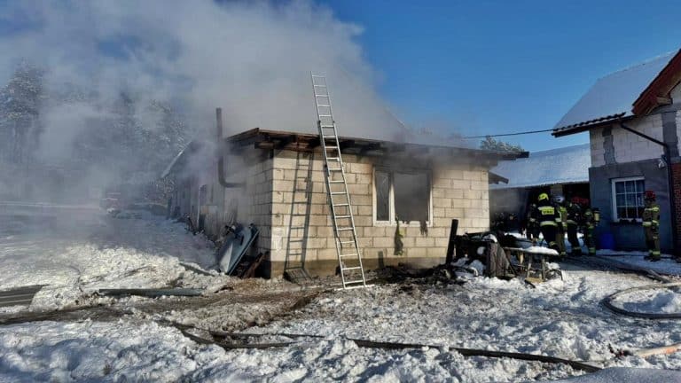 Pożar budynku gospodarczego w Inulcu z widocznym dymem i strażakami na miejscu działań.