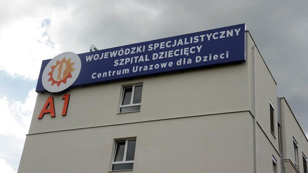 Widok na budynek szpitala dziecięcego z dużym oznaczeniem i nazwą plac&oacute;wki.
