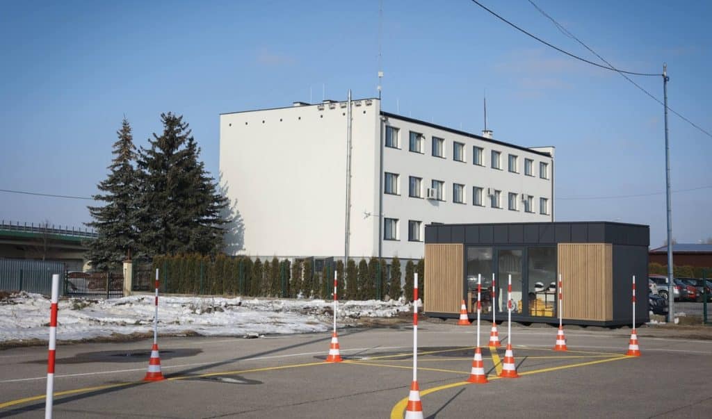 Nowa siedziba WORD w Ełku, budynek i stanowisko do egzamin&oacute;w na prawo jazdy, otoczone słupkami i oznaczeniami.