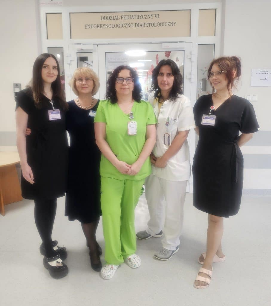 Grupa pracownik&oacute;w szpitala wchodząca do odnowionego oddziału pediatrycznego w Olsztynie.