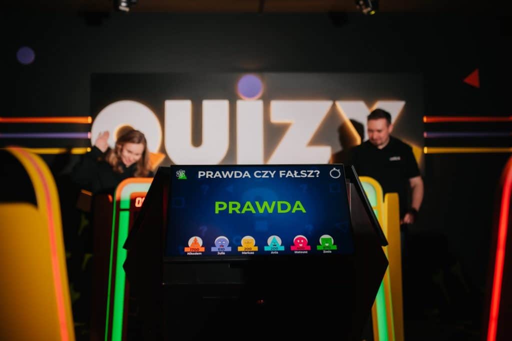 Gra na ekranie quizu w centrum Olsztyna, w tle widoczny napis 'Quiz'.