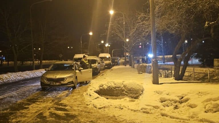 Zimowa noc na ulicy w Kortowie z uszkodzonym gazociągiem i samochodami na drodze.