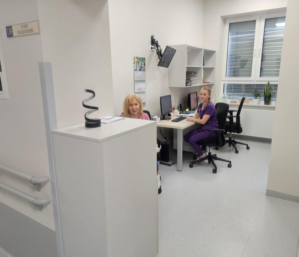 Nowoczesne pomieszczenia w szpitalu dziecięcym, widok na biurka i personel medyczny.