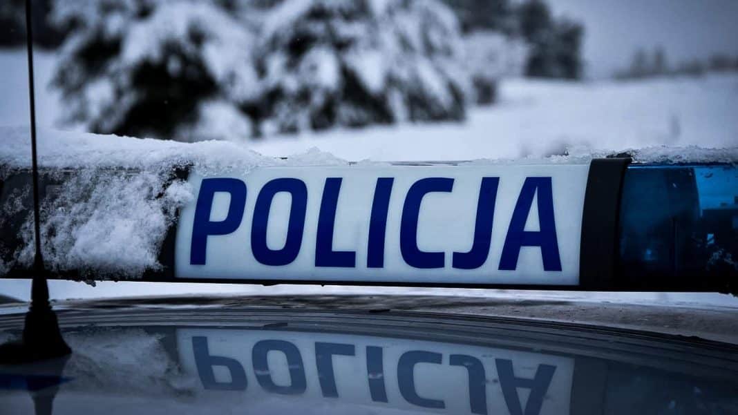 Zdjęcie policyjnego oznakowania na tle zaśnieżonego otoczenia, z napisem 'POLICJA'.