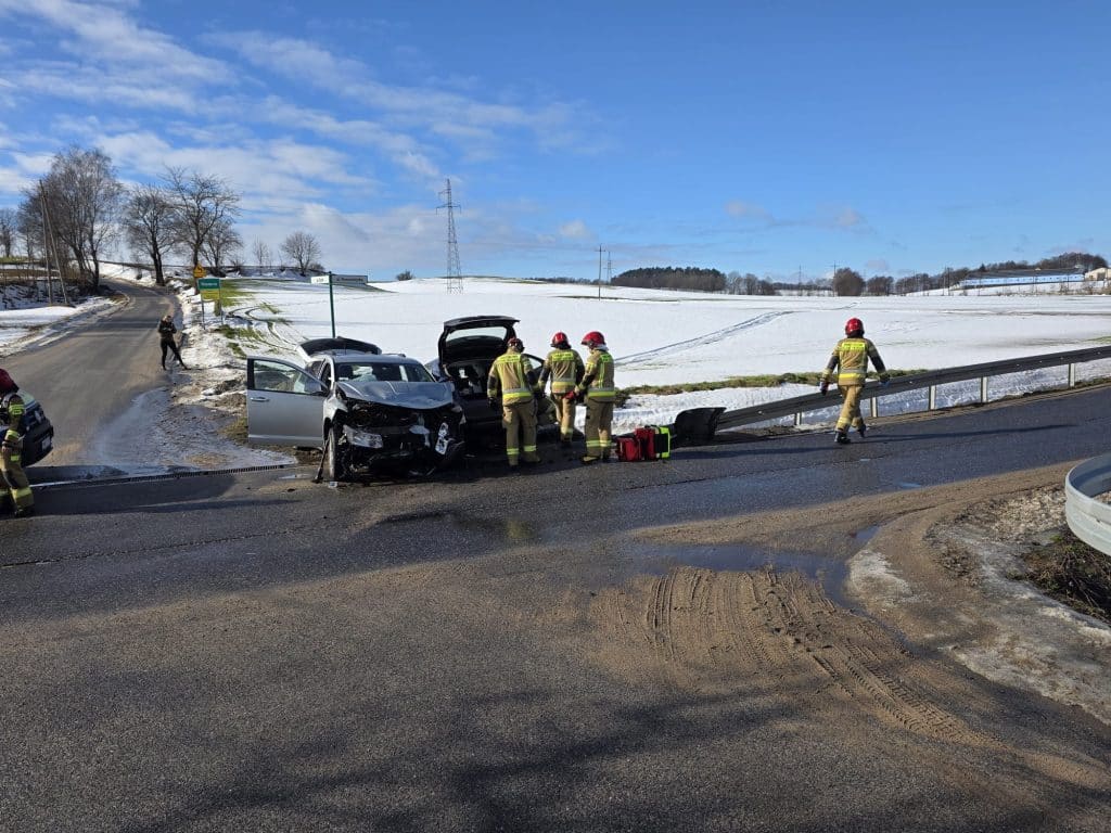 Wypadek na skrzyżowaniu w Bratianie, zderzenie dw&oacute;ch samochod&oacute;w, straż pożarna i ratownicy na miejscu.