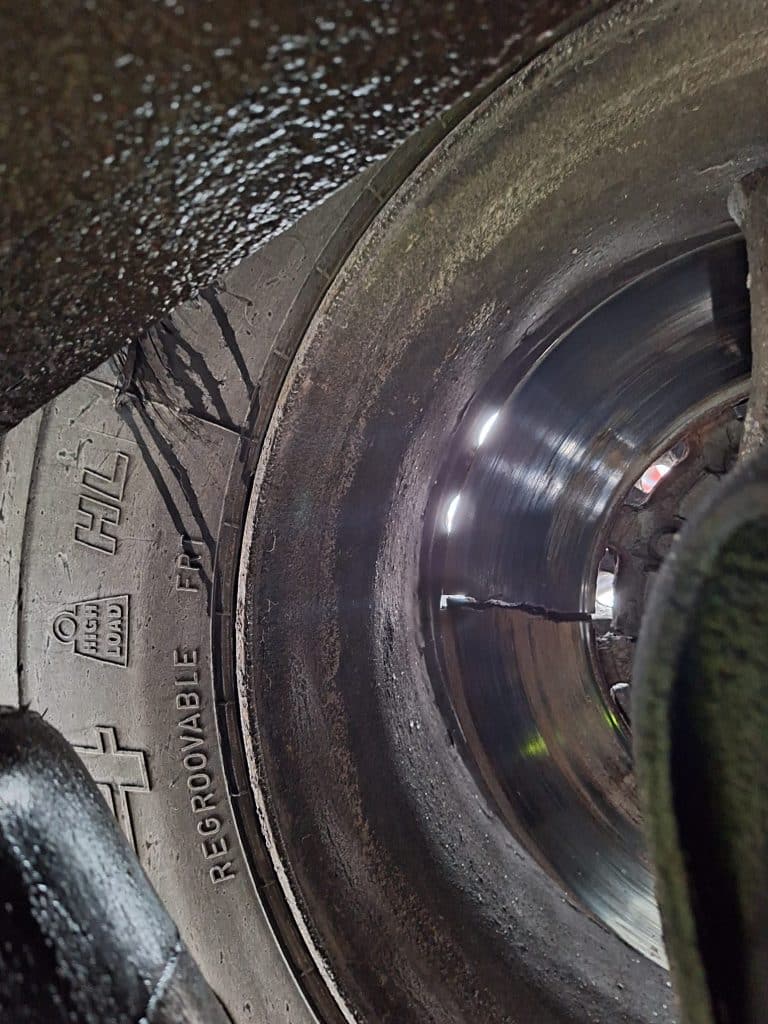 Zbliżenie na zużyte i pęknięte tarcze hamulcowe ciężar&oacute;wki na drodze.