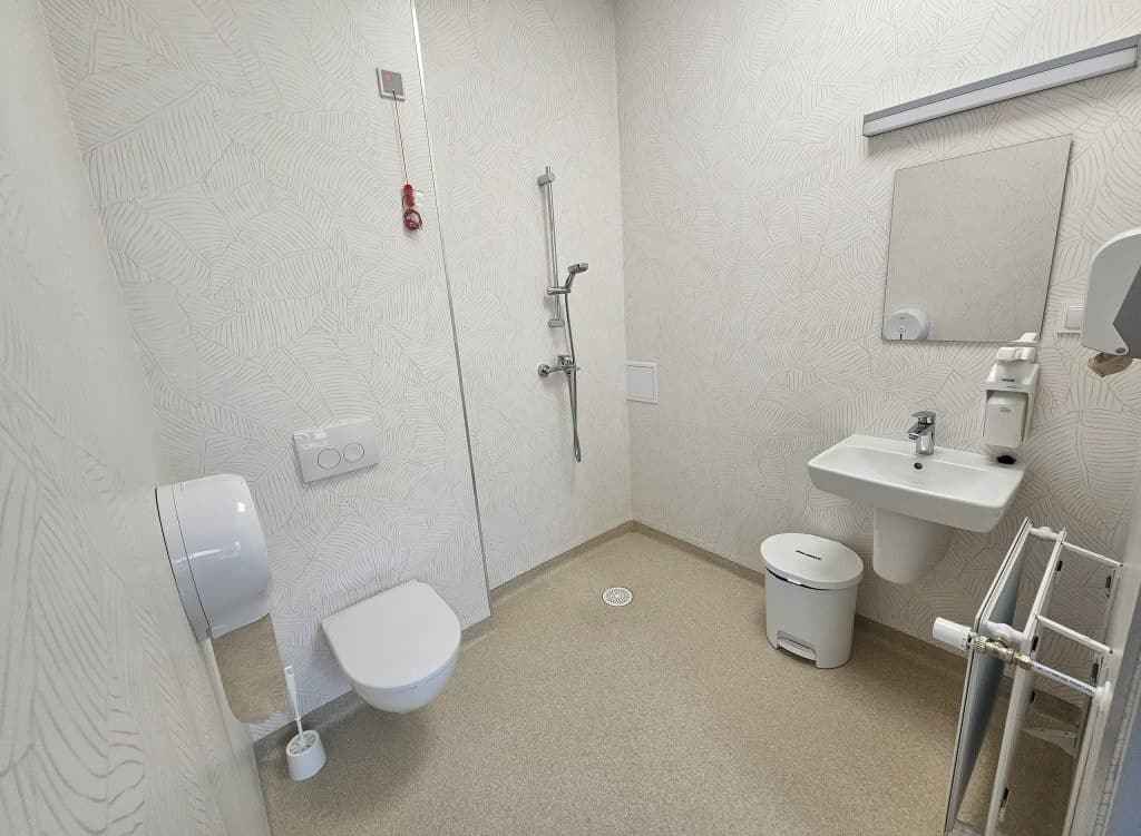 Nowa, przestronna sala w szpitalu dziecięcym z łazienkami i monitoringiem.