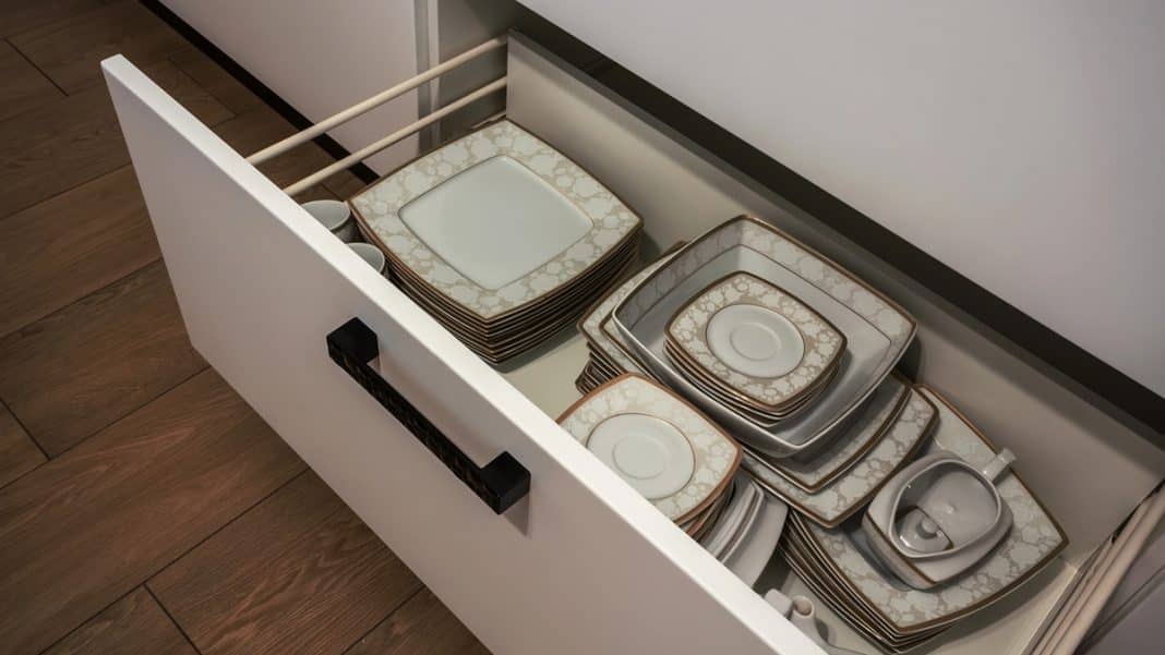 Szuflada kuchni z ułożonymi organizerami na talerze i sztućce, widok z g&oacute;ry.