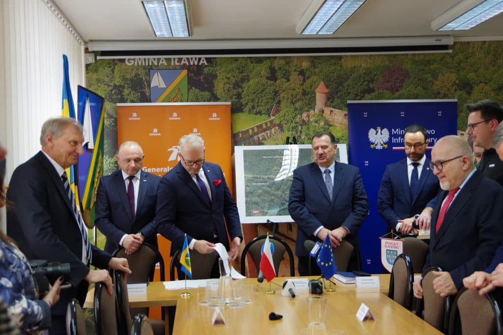 Grupa urzędnik&oacute;w i przedstawicieli podczas podpisania umowy na budowę wiaduktu na DK16 w Iławie.