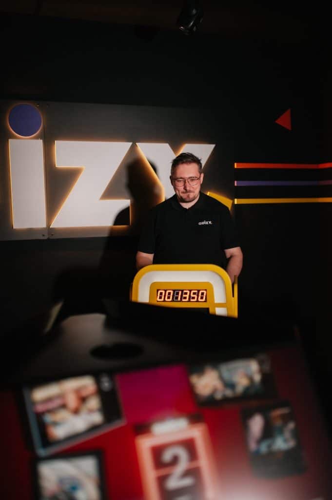 Mężczyzna stoi przy urządzeniu do gry w quizy w nowym centrum rozrywki w Olsztynie.