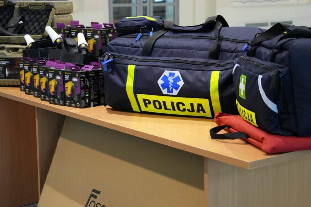 Sprzęt policyjny i torby na wyposażenie na stole w pomieszczeniu.