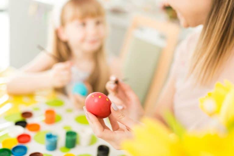 Dziecko maluje na jajku podczas zajęć plastycznych w przedszkolu.