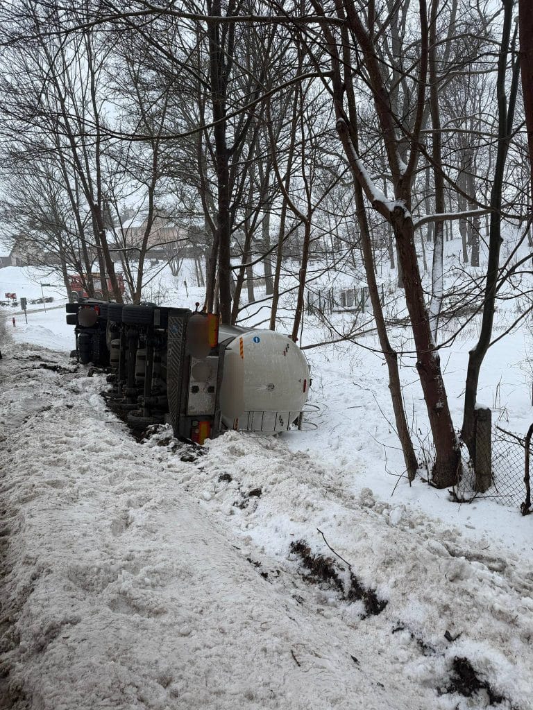 Wywr&oacute;cony na bok ciężar&oacute;wka na zaśnieżonym poboczu drogi krajowej nr 16.