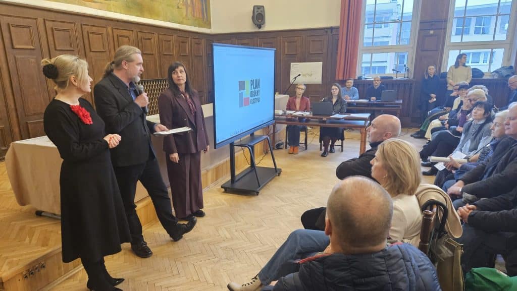 Sala urzędu miasta wypełniona mieszkańcami podczas konsultacji społecznych.