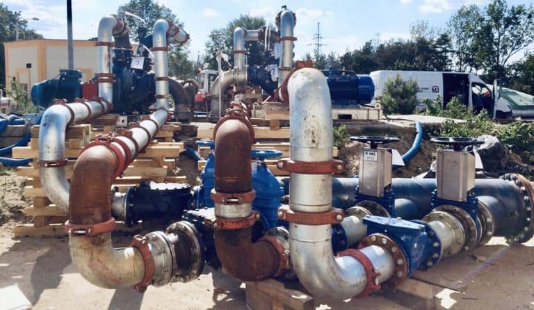Przemysłowe systemy transportu cieczy z rur i pomp na placu budowy.