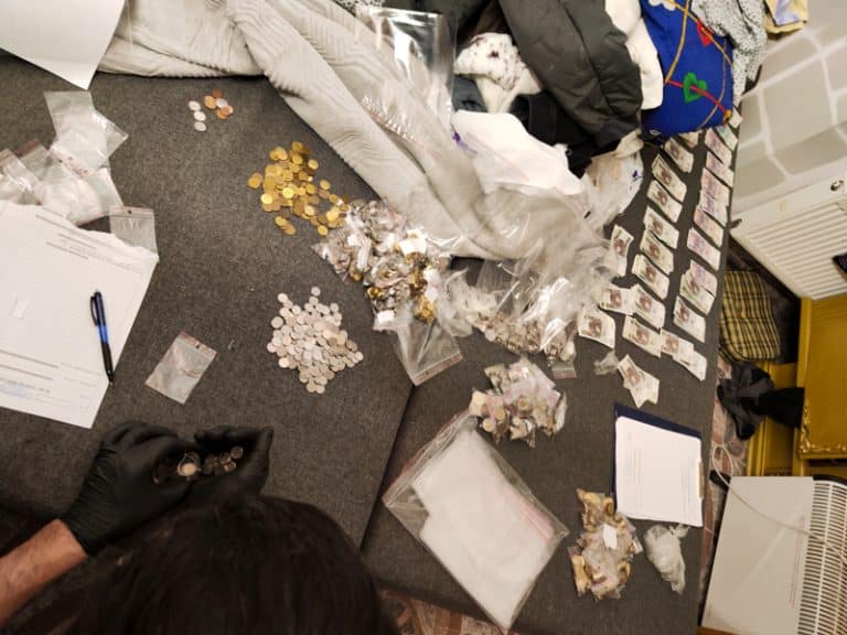 Na zdjęciu rozłożone pieniądze i dokumenty na podłodze w pomieszczeniu.