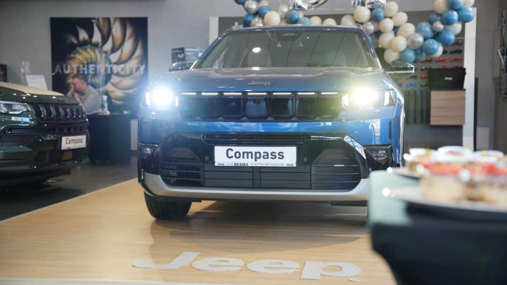 Nowy Jeep Compass na wystawie w Olsztynie, z jasnym oświetleniem i nowoczesnym wnętrzem.