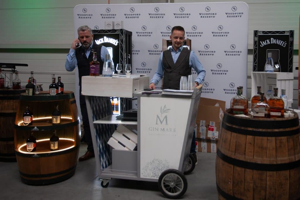 Stoiska z alkoholem i degustacje na targach w Gdańsku, uczestnicy rozmawiają i prezentują produkty.