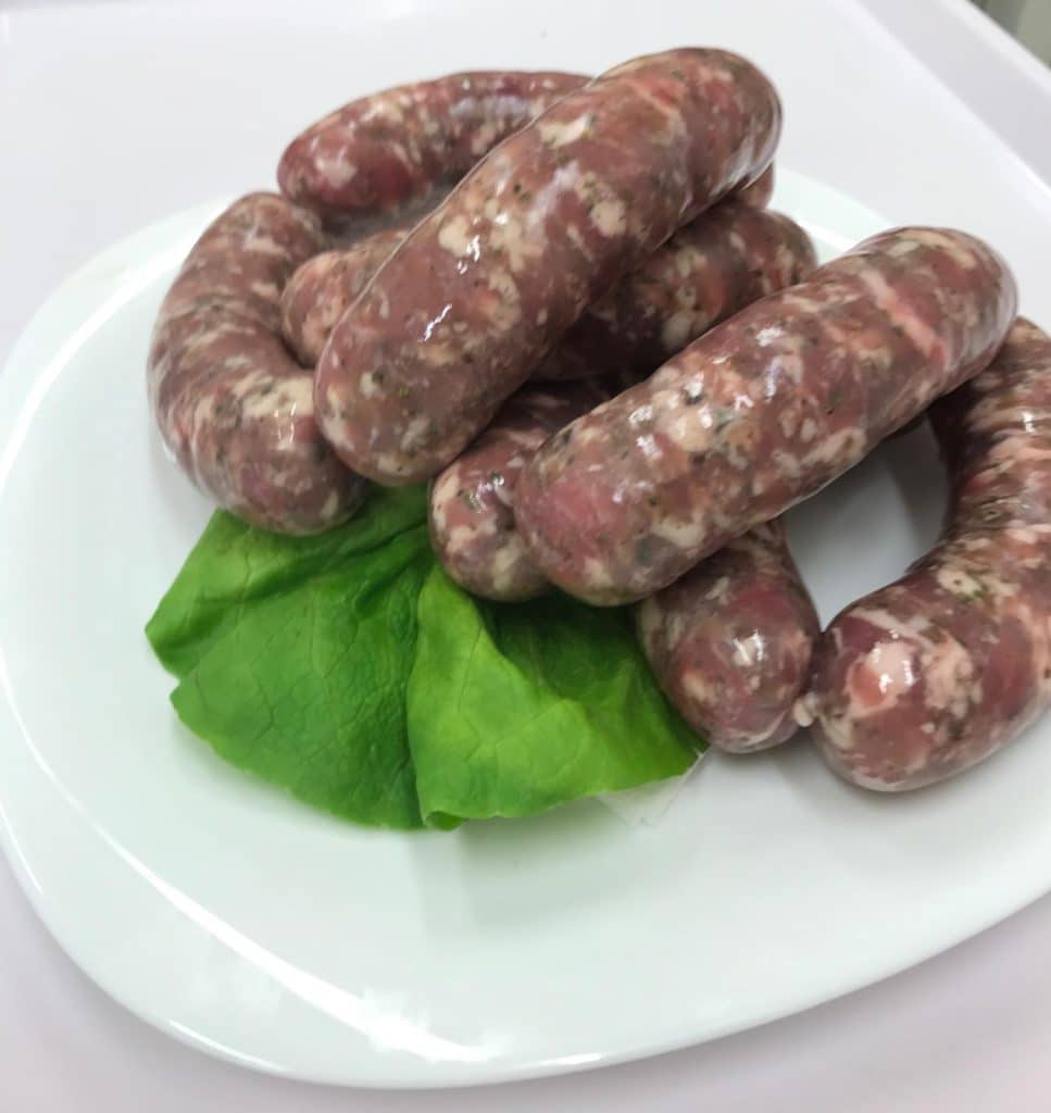 Biała kiełbasa na świątecznym talerzu z liściem sałaty, przygotowana do Wielkanocy.