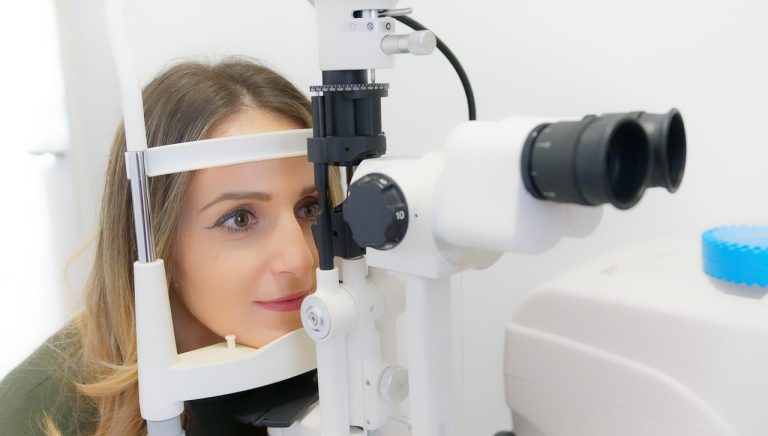 Kobieta podczas badania wzroku przy użyciu urządzenia optometrycznego.