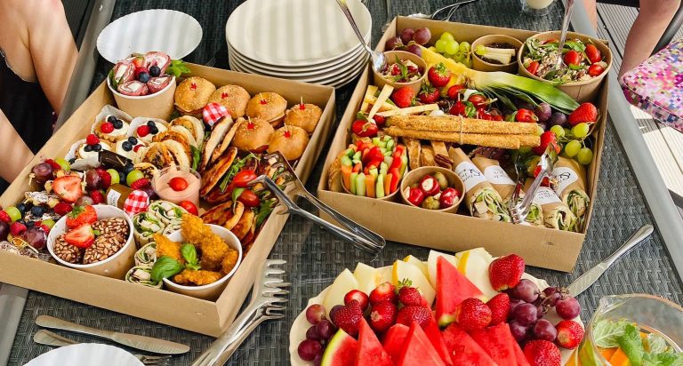 Talerz pełen r&oacute;żnorodnych owoc&oacute;w i przekąsek na cateringowe spotkanie.