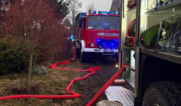 Straż pożarna na miejscu zdarzenia w miejscowości Gady, pod Olsztynem, z wężami gaśniczymi i pojazdem ratowniczym.