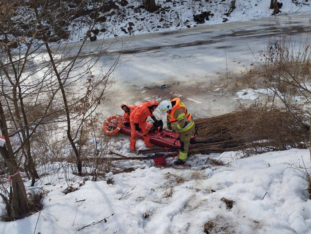 Ratownicy wyciągają mężczyznę z zamarzniętej rzeki Wałsza podczas akcji ratunkowej.