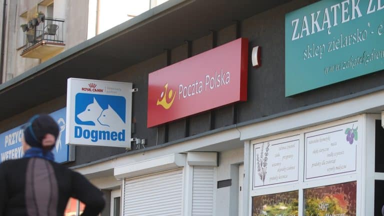 Widok z zewnątrz na plac&oacute;wki pocztowe i sklep zoologiczny na budynku.