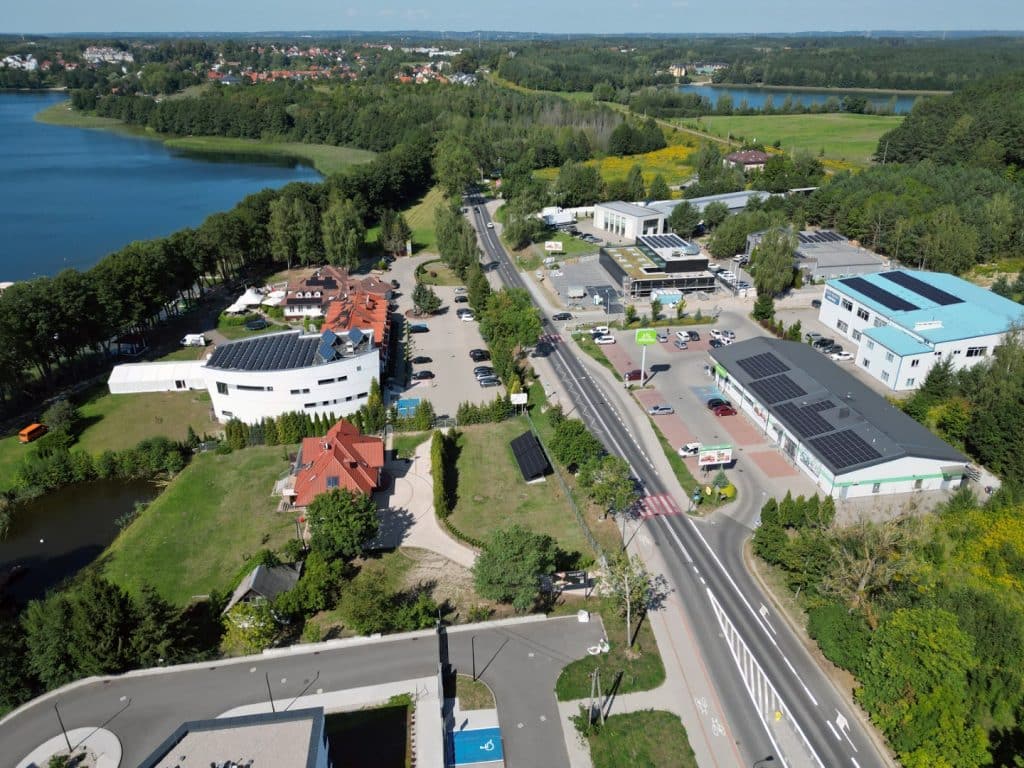 Widok na jezioro Ukiel i otaczającą infrastrukturę w Olsztynie, z zielonymi terenami i zabudową.