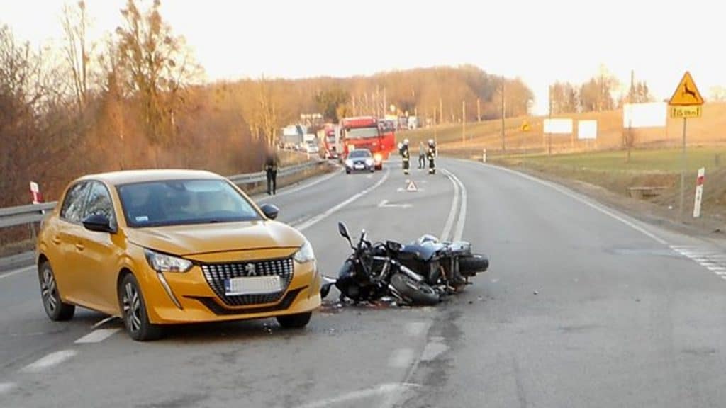 Wypadek na DK16 z udziałem motocykla i samochodu, na miejscu służby ratunkowe.