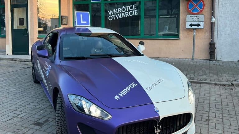 Samoch&oacute;d szkoleniowy Maserati z logo szkoły nauki jazdy Hirpol na ulicy w Olsztynie.