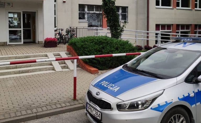 Policja zabezpiecza teren wok&oacute;ł szkoły podstawowej na Mazurach, w pobliżu wejścia do budynku.
