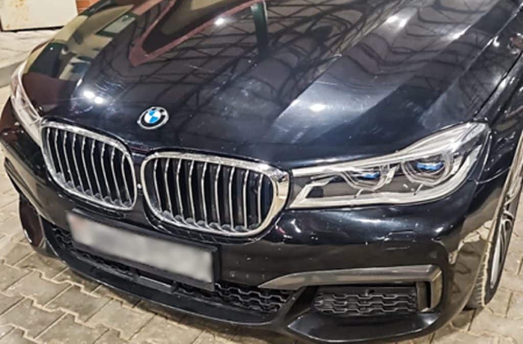 Czarne BMW z widocznymi zmienionymi tablicami rejestracyjnymi na granicy polsko-rosyjskiej.