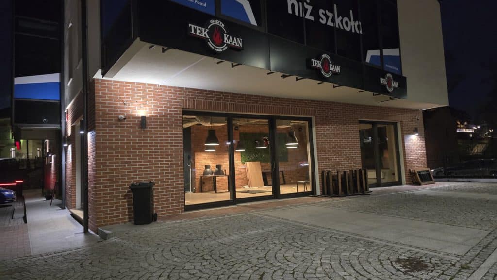 Budynek przy ul. Staszica 6 w Olsztynie z zamkniętymi drzwiami i informacją o wstrzymaniu działalności, nocą.