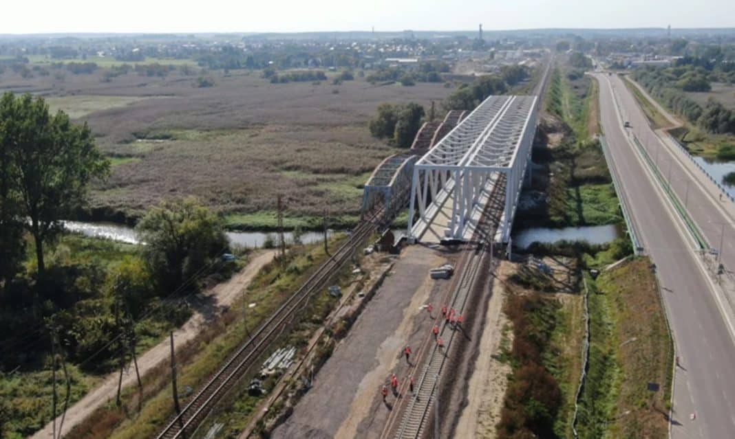 Widok na modernizowany odcinek linii kolejowej Rail Baltica z nowym wiaduktem nad torami.