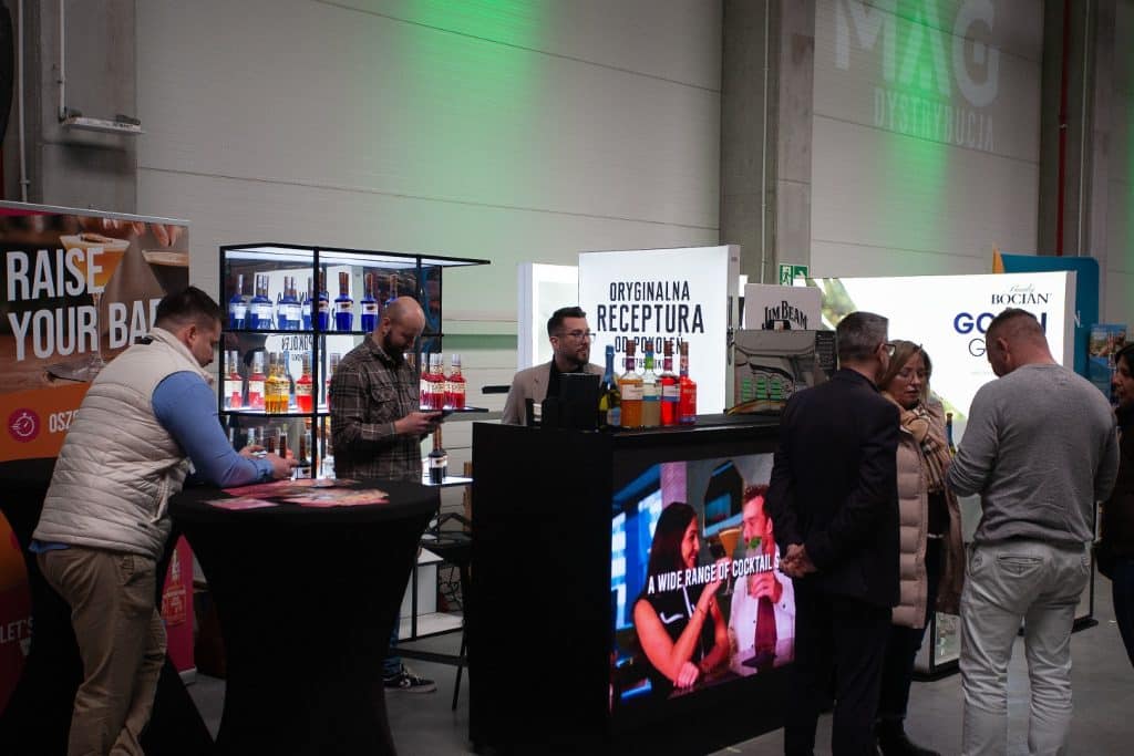 Uczestnicy targ&oacute;w biznesowych w Gdańsku rozmawiają przy stoiskach z napojami i produktami dla sektora HoReCa.