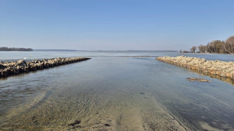 Widok na odcinek kanału na Mazurach po zakończeniu prac modernizacyjnych, z widoczną wodą i brzegami.
