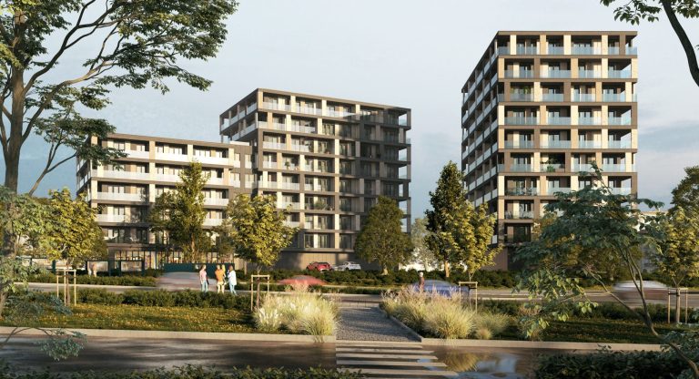 Nowoczesne budynki mieszkalne z balkonami, otoczone zielenią i drzewami, w słoneczny dzień.