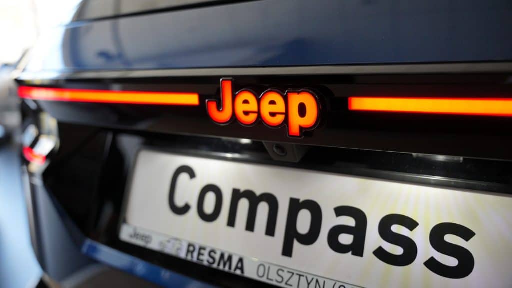 Zbliżenie na tył nowego Jeepa Compassa z podświetlanym logo marki.