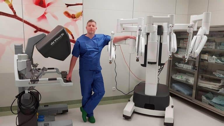 Lekarz w szpitalu obok robota chirurgicznego Da Vinci, używanego do operacji raka prostaty.