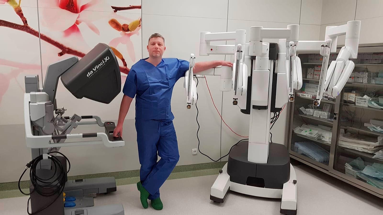 Lekarz w szpitalu obok robota chirurgicznego Da Vinci, używanego do operacji raka prostaty.