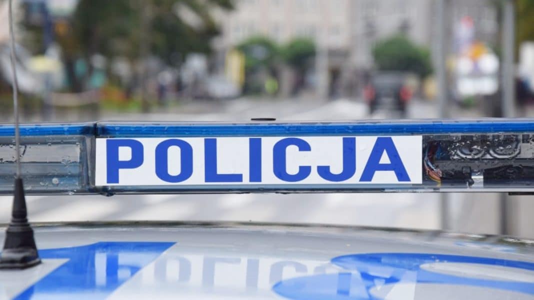 Widok policyjnej blokady na drodze podczas kontroli kierowcy motoroweru w mieście.